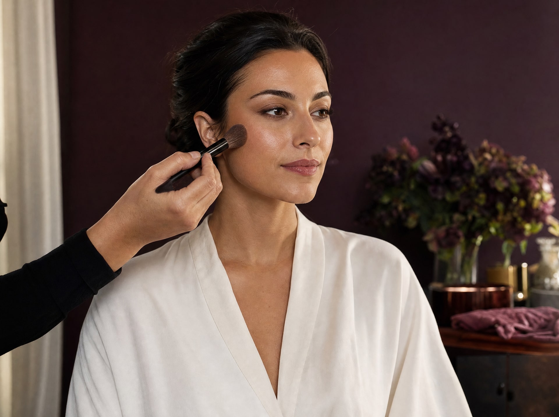 Application de maquillage au pinceau sur la pommette d’une cliente.